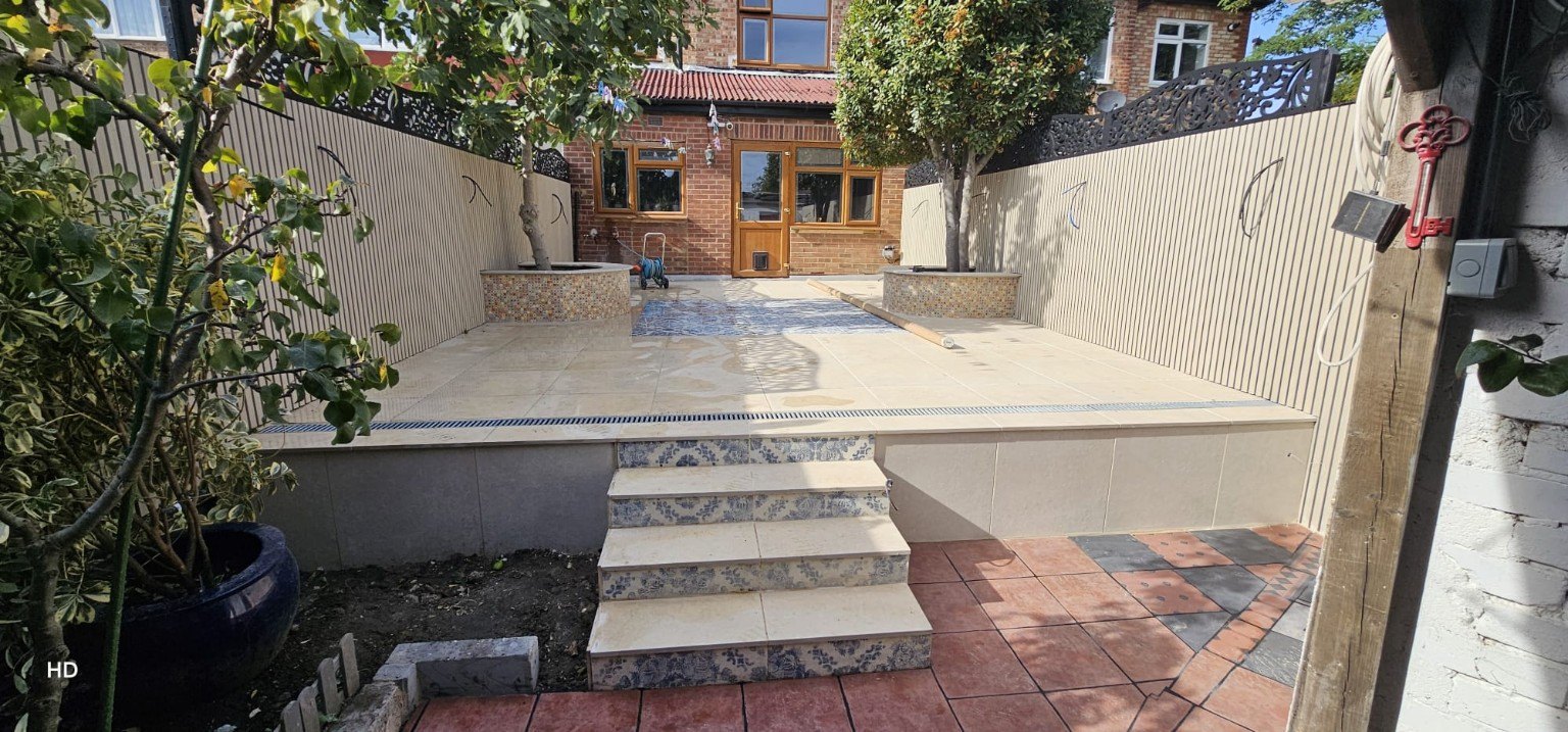 Finished raised patio with paved steps and a tiled garden area