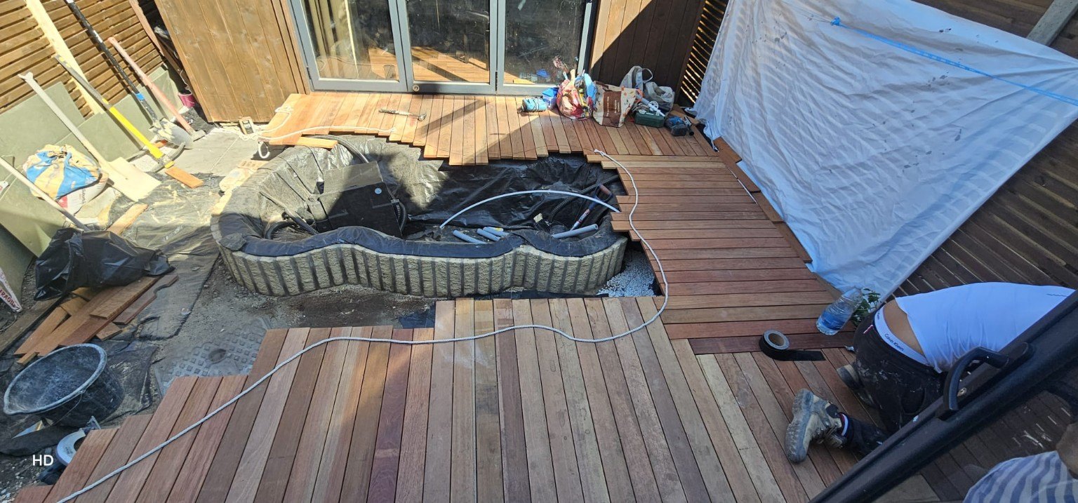 Timber decking being fitted around the garden pond